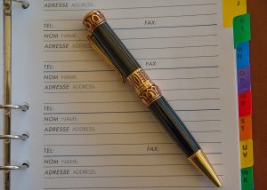 An address book open with an ornate pen on top of it.