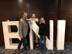 A BNI sign with three people standing around it.