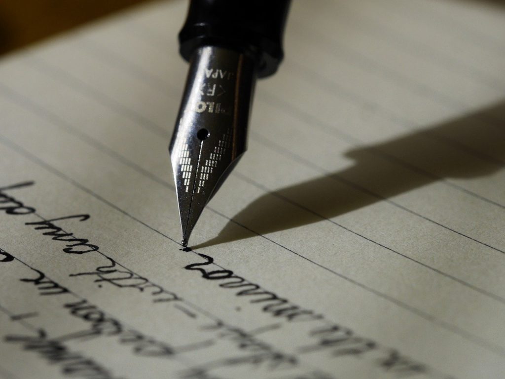 Someone writing a list with pen and paper.
