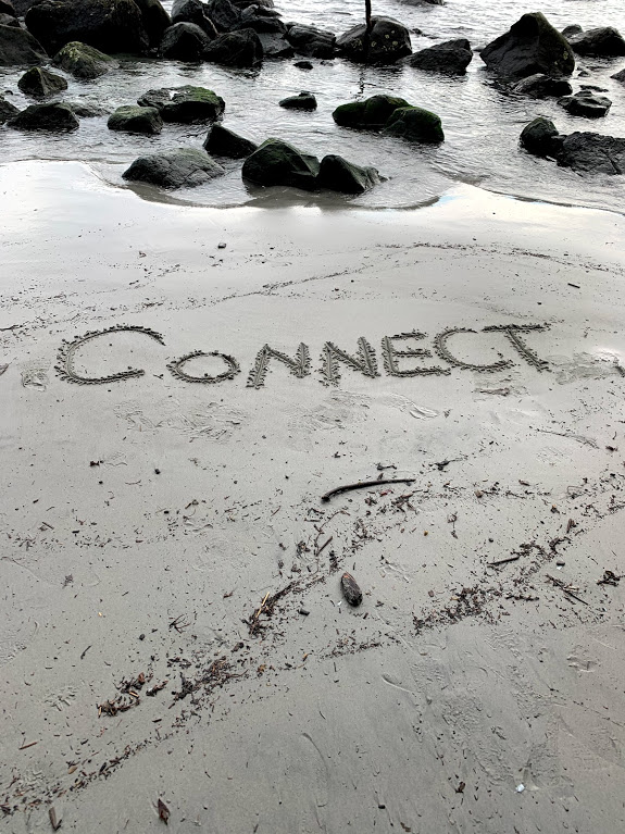 The word connect written on the beach sand.