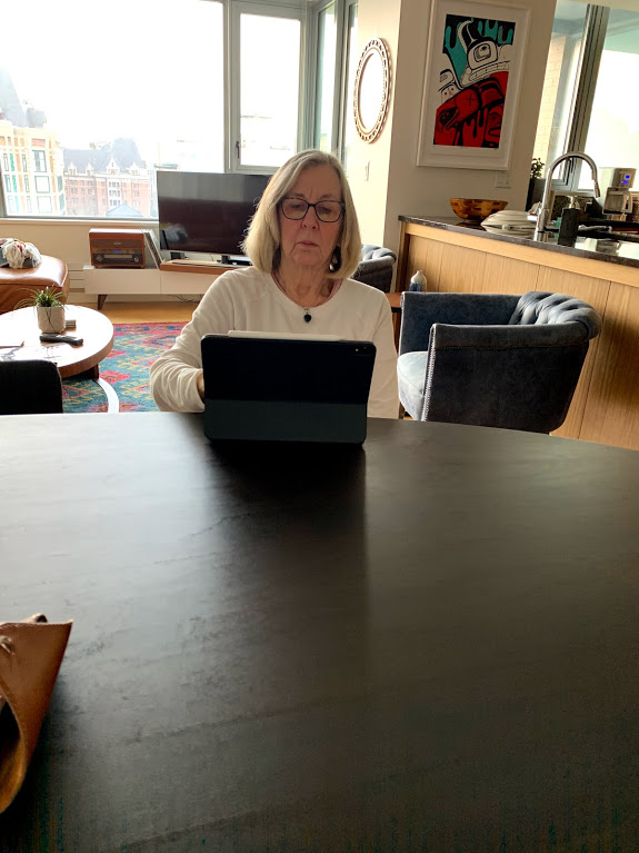 A woman working on her laptop in the dining room.
