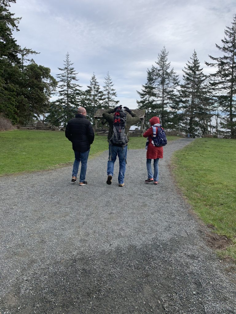 Three people walking down a path and talking.