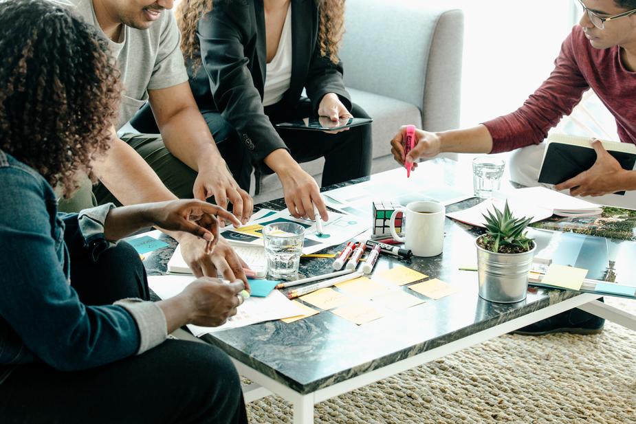A coffee table with a group of people discussing ideas.