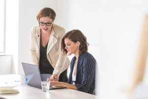 Two woman looking at a computer screen.