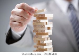 A man playing Jenga stacking up the blocks.